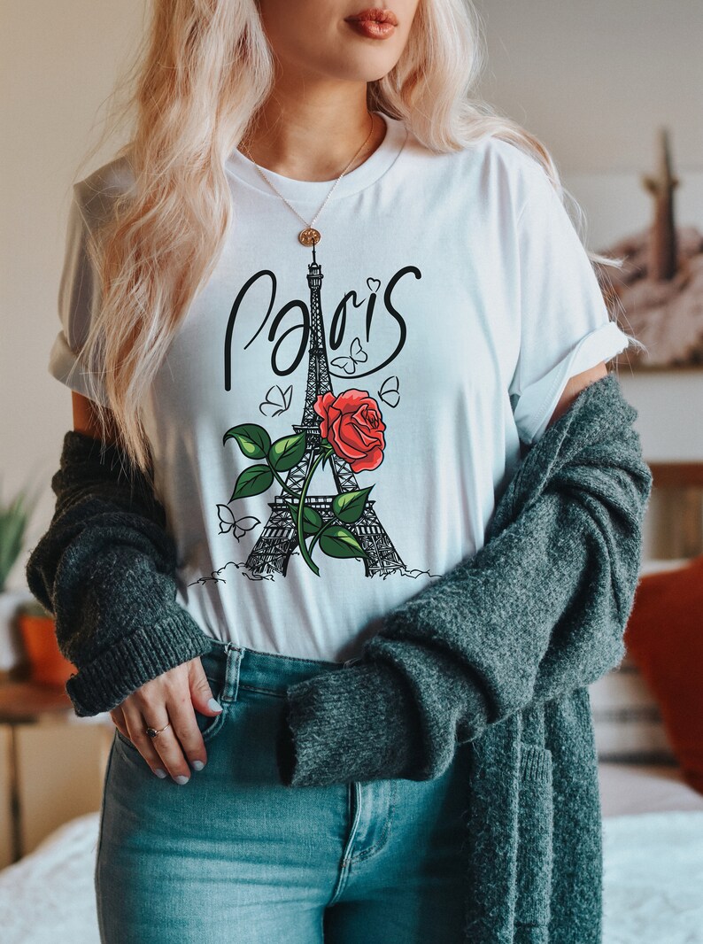 May include: White t-shirt with a black and white illustration of the Eiffel Tower and a red rose. The text "Paris" is written in cursive above the tower.