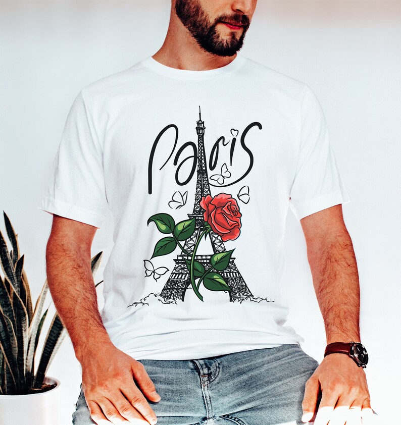 May include: White t-shirt with a black and white illustration of the Eiffel Tower, a red rose, and butterflies. The word "Paris" is written in cursive above the tower.