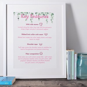 May include: A white framed poster with the title "Key Features" in pink text. The poster lists the features of a t-shirt, including side seams, ribbed knit collar with seam, shoulder tape, and fiber composition. The poster includes illustrations of a t-shirt, a collar, and a shoulder seam.