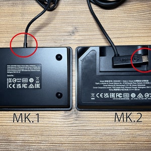 May include: Two black rectangular electronic devices labeled MK.1 and MK.2. The MK.1 has a fixed cable connection, while the MK.2 features a detachable USB-C cable with an Elgato logo. Both units display regulatory markings and model information.