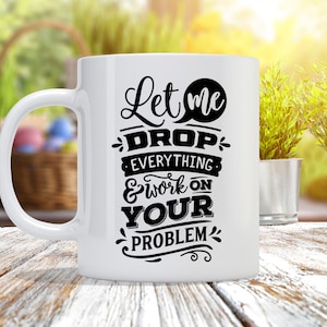 May include: White ceramic coffee mug with a black design that reads "Let me drop everything & work on your problem".