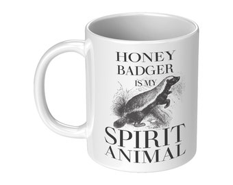 May include: White ceramic mug with a black and white illustration of a honey badger and the text "Honey Badger is my Spirit Animal".