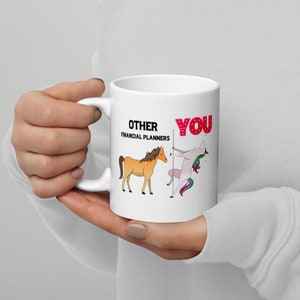 May include: White ceramic mug with a black and red graphic. The graphic shows a horse and a unicorn with the text "Other Financial Planners" and "You".