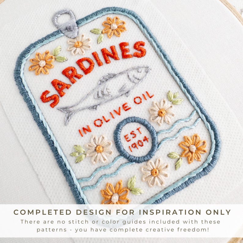 Close-up image of a completed stick and stitch embroidery pattern depicting a sardine tin labeled “Sardines in Olive Oil” with “EST 1904” and decorative floral details. The design is stitched in red, orange, blue, and pastel tones. A banner at the bottom reads: “COMPLETED DESIGN FOR INSPIRATION ONLY – There are no stitch or color guides included with these patterns – you have complete creative freedom!”