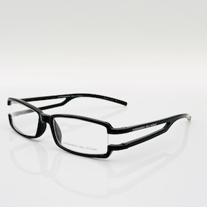 May include: Black plastic framed eyeglasses with clear lenses. The brand name "Alessandro Dell'Acqua" is printed on the frame.
