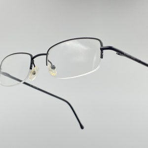 Puede incluir: Gafas de metal negro con lentes transparentes. El nombre de la marca "TOMMY HILFIGER" está impreso en la patilla derecha.