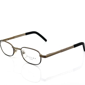 May include: Oval-shaped eyeglasses with a bronze-colored frame and black temple tips. The brand name "SISLEY" is visible on the temple. The glasses are designed for vision correction.