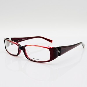 May include: Red and black eyeglasses with clear lenses. The brand name "POLICE" is printed on the frame.