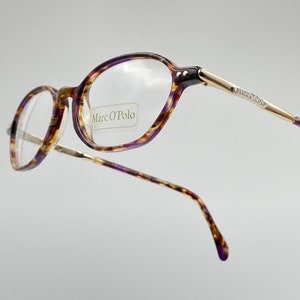 May include: Purple and brown tortoise shell eyeglasses with gold accents. The brand name "Marc O'Polo" is printed on the right lens.