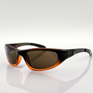 May include: Brown and black sunglasses with brown lenses. The sunglasses have a curved frame and a black stripe on the side.