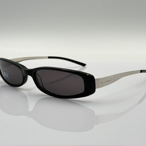 Puede incluir: Gafas de sol negras con patillas plateadas y la inscripción "BLUERAY" en la patilla derecha.