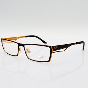 Puede incluir: Un par de gafas Ray-Ban marrones y doradas con lentes transparentes.