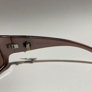 May include: Brown sunglasses with a silver hinge and the text "Versace Collection Made in Italy" on the arm.