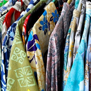 vintage '90s Hawaiian shirts displayed. Each shirt features different patterns such as lush landscapes, exotic flowers, and classic beach scenes, embodying a retro and relaxed vibe perfect for vacations or as a unique gift