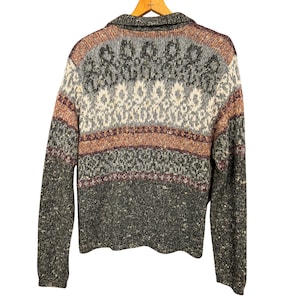 May include: A vintage collared sweater in shades of gray, brown, and cream, with a patterned design across the chest and upper back. The sweater is made of a textured knit fabric and has long sleeves.