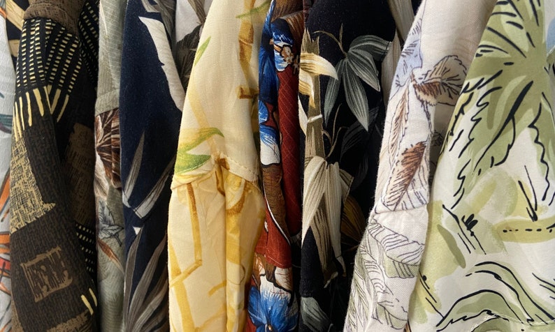 vintage '90s Hawaiian shirts displayed. Each shirt features different patterns such as lush landscapes, exotic flowers, and classic beach scenes, embodying a retro and relaxed vibe perfect for vacations or as a unique gift