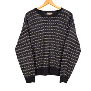 May include: A vintage crew neck jumper with a checkered pattern in navy blue, grey, and tan. The jumper is displayed on a wooden hanger against a white background. The jumper has long sleeves and a ribbed hem.