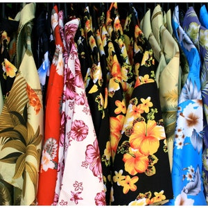 vintage '90s Hawaiian shirts displayed. Each shirt features different patterns such as lush landscapes, exotic flowers, and classic beach scenes, embodying a retro and relaxed vibe perfect for vacations or as a unique gift