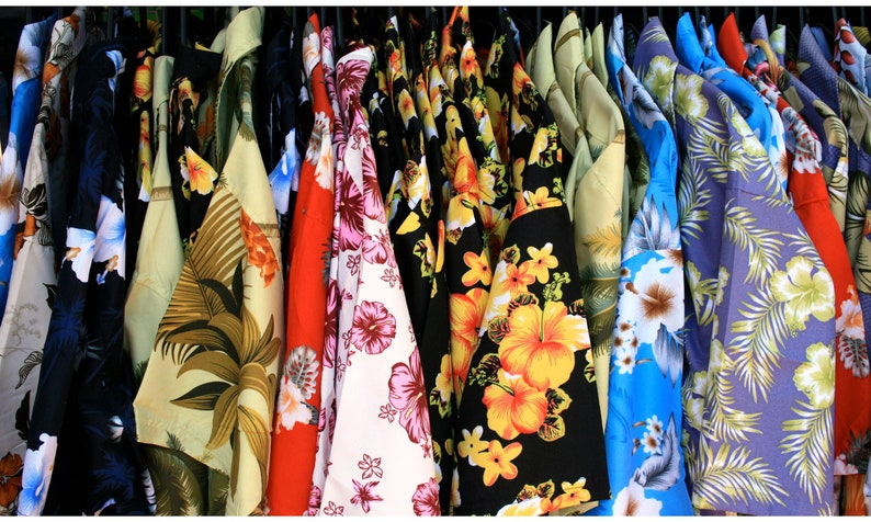 vintage '90s Hawaiian shirts displayed. Each shirt features different patterns such as lush landscapes, exotic flowers, and classic beach scenes, embodying a retro and relaxed vibe perfect for vacations or as a unique gift