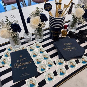 May include: A retirement party setup with navy blue and white decorations. Includes floral arrangements, a navy blue cup with "Retired 2025", stickers, napkins with "Cheers to Retirement", and a card that says "Happy Retirement".