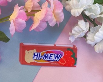 Puede incluir: Un envoltorio de chicle de fresa rosa y blanco con el texto "HI-MEW" y una ilustración de un gato de dibujos animados.