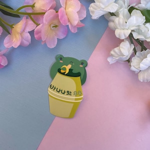 Glänzender Vinyl Gestanzter Aufkleber Niedliche koreanische Bananen-Milch-Getränk-Snack-Frosch-Aufkleber