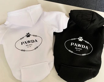 May include: Two dog hoodies, one white and one black, with a paw print logo that says "PAWDA MILANO DAL 1918".