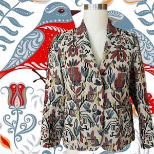 May include: A beige blazer with a colorful floral and geometric pattern. The jacket features a notched collar, two front pockets, and a two-button closure. The background has a folk art bird and floral design.