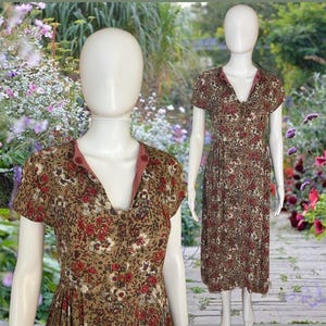 May include: A brown and beige floral print midi dress with a pink button-up collar and short sleeves.