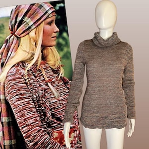 Könnte beinhalten: Ein braun-rot gestreifter Rollkragenpullover auf einer Schaufensterpuppe. Der Pullover hat lange Ärmel und eine gerippte Textur. Das Bild zeigt auch eine Frau, die ein passendes gestreiftes Oberteil und ein Kopftuch trägt.