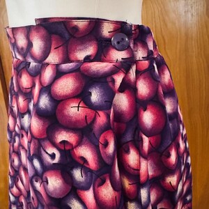 Peut inclure: Jupe taille haute avec un imprim&eacute; cerise vif dans les tons de rouge, violet et blanc. La jupe a une fermeture boutonn&eacute;e et un design pliss&eacute;. Le tissu est une mati&egrave;re douce.