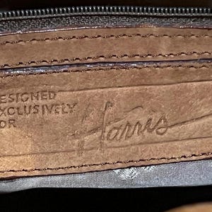 May include: Close-up of a brown leather label with the text "DESIGNED EXCLUSIVELY FOR Harris" embossed in the leather.