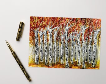 May include: A rectangular print featuring a watercolor painting of a dense birch forest with white trunks and vibrant orange and red autumn leaves, accompanied by a black and gold floral patterned pen with its cap placed nearby.