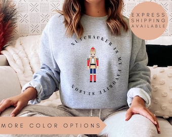 May include: Gray sweatshirt with a graphic of a nutcracker and the text "Nutcracker is my favorite season".