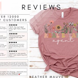 May include: A heather mauve t-shirt featuring a floral design and the text "Real Estate Agent" in rainbow colours. The shirt is displayed on a white wooden surface. The image also includes customer reviews with five-star ratings.