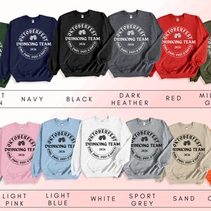 a collection of sweatshirts with the same design, arranged in two rows. The sweatshirts feature the text "OKTOBERfest Drinking Team" and are available in various colors and styles.