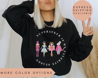 Puede incluir: Sudadera negra con un gráfico blanco de una escena de Cascanueces. El texto dice "Cascanueces es mi estación favorita".