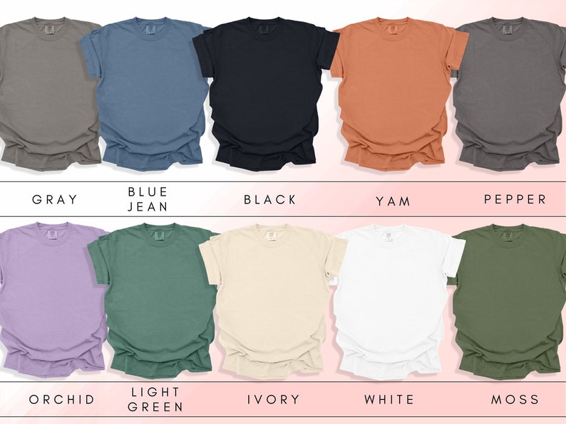 K&ouml;nnte beinhalten: Eine Sammlung von zehn leeren T-Shirts in verschiedenen Farben, darunter Grau, Jeansblau, Schwarz, Yam, Pfeffer, Orchidee, Hellgr&uuml;n, Elfenbein, Wei&szlig; und Moos.