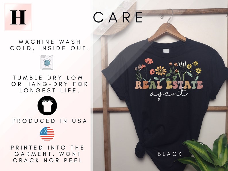May include: Black t-shirt with a floral design and the text "REAL ESTATE agent". The shirt is on a hanger and has care instructions printed on the left side of the image.