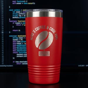 Könnte beinhalten: Ein roter isolierter Becher mit einem silbernen Deckel. Der Becher zeigt den Text "ALICE'S COFFEE & CODE FUEL" um ein Kaffeebohnen-Design, das mit Binärcode und einer Tastatur gefüllt ist. Im Hintergrund ist Computercode zu sehen.