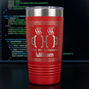 May include: A red insulated tumbler with a silver lid. The tumbler features the text "Ctrl Alt Caffeinate" and the name "William" in silver. The design includes coffee cup icons and binary code patterns, perfect for a programmer or coder.