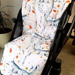 Könnte beinhalten: Ein weißer Kinderwagen-Sitzbezug mit einem Waldmuster mit grauen Wölfen, Sternen, Monden und Blättern. Der Bezug ist aus weichem, atmungsaktivem Stoff gefertigt und passt auf die meisten Standard-Kinderwagen-Sitze.