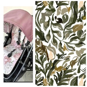 Könnte beinhalten: Ein Kinderwagen mit einem rosafarbenen Verdeck und einem Sitz mit floralem Muster. Der Sitz hat ein Design aus rosa und weißen Blumen. Der Rahmen des Kinderwagens ist schwarz. Neben dem Kinderwagen befindet sich ein weißer Hintergrund mit einem grünen, braunen und beigen Blättermuster.