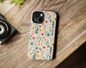 Könnte beinhalten: Eine Blumen-Handyhülle mit weißem Hintergrund und verschiedenen rosa, blauen und gelben Blumen. Die Hülle hat einen Ausschnitt für die Kamera.