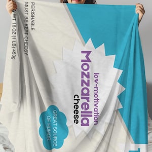 May include: A white and blue blanket with the text "low-motivation Mozzarella cheese" in purple and white. The blanket also has the text "PERISHABLE MUST BE KEPT CHEESY VWT 16 OZ (1 LB) 453g GREAT SOURCE OF HUMOR 1".
