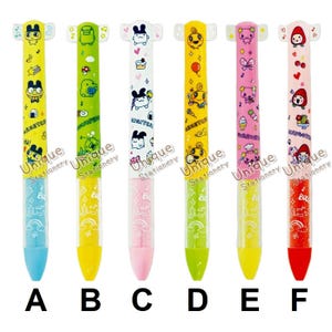 May include: Six colorful pens with cartoon character designs. Each pen features a different color scheme, including yellow, green, white, yellow, pink, and red. The pens have a unique design with a character head at the top and a clear barrel with a colored tip. The pens are labeled A through F.