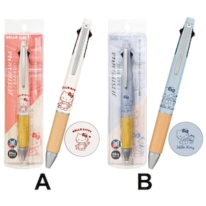 May include: Two Jetstream 4&1 multi-pens with bamboo grips and Hello Kitty graphics. Pen A is cream with red ink details, and Pen B is light blue with blue ink details. Both feature 0.5mm tips, silver clips, and are in clear retail packaging.
