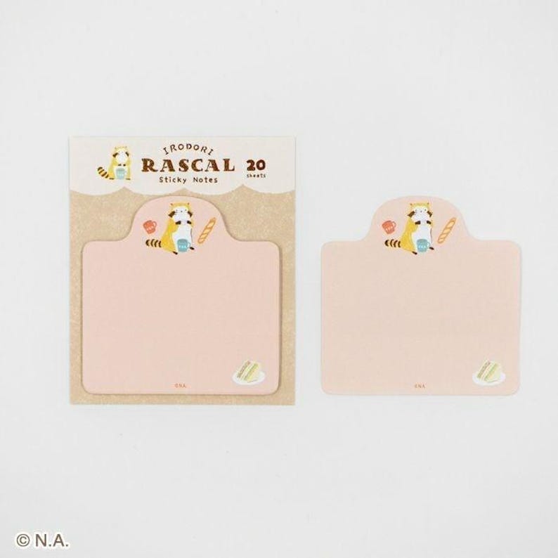May include: A set of Irodori Rascal sticky notes. The packaging is light brown with the text "Irodori Rascal 20 Sticky Notes". The sticky notes are light pink with a cartoon raccoon illustration and a small cake illustration.
