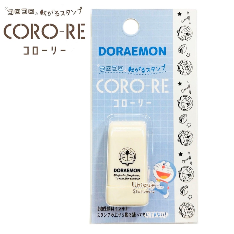 Puede incluir: Un sello con el tema de Doraemon en una carcasa de pl&aacute;stico color crema. El embalaje es azul claro con las palabras "CORO-RE" y "DORAEMON" impresas. El sello presenta un gr&aacute;fico de Doraemon y las palabras "Unique Stationery".