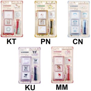 May include: Five Sanrio Characters Hancoco slide stamp sets in individual blister packaging. Each set includes three square stamps with character graphics and one ink pad. The sets feature Hello Kitty, Pompompurin, Cinnamoroll, Kuromi, and My Melody designs with coordinating colored plastic casings and ink.